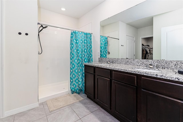 bathroom featuring tile patterned flooring, a sink, and a stall shower