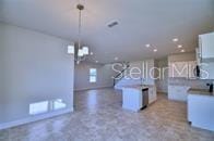 kitchen featuring decorative light fixtures, open floor plan, and a center island with sink