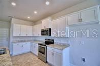 kitchen featuring light countertops, recessed lighting, white cabinets, and appliances with stainless steel finishes