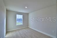 carpeted spare room featuring baseboards