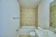 full bath featuring washtub / shower combination, vanity, and toilet