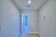 corridor featuring baseboards and visible vents