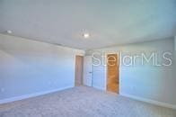 carpeted empty room with baseboards