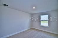 unfurnished room with baseboards, carpet flooring, and visible vents