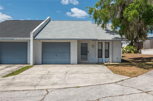 6315 Conductor Ct, Lakeland, FL 33813 - ranch-style home featuring an attached garage, a shingled roof, concrete driveway, and stucco siding