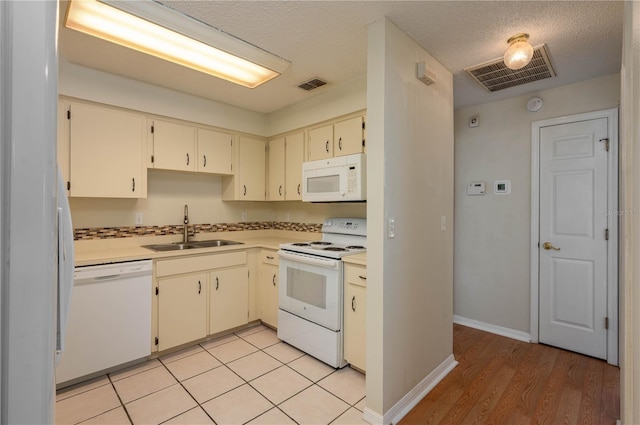 6315 Conductor Ct, Lakeland, FL 33813 - kitchen with visible vents, white appliances, a sink, and cream cabinetry