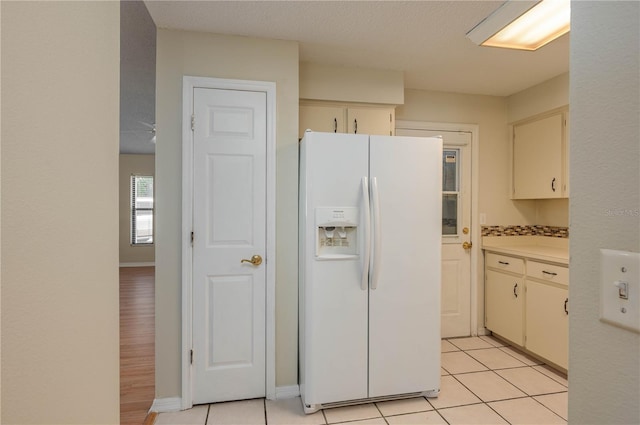 6315 Conductor Ct, Lakeland, FL 33813 - kitchen featuring cream cabinets, light tile patterned flooring, white fridge with ice dispenser, and light countertops