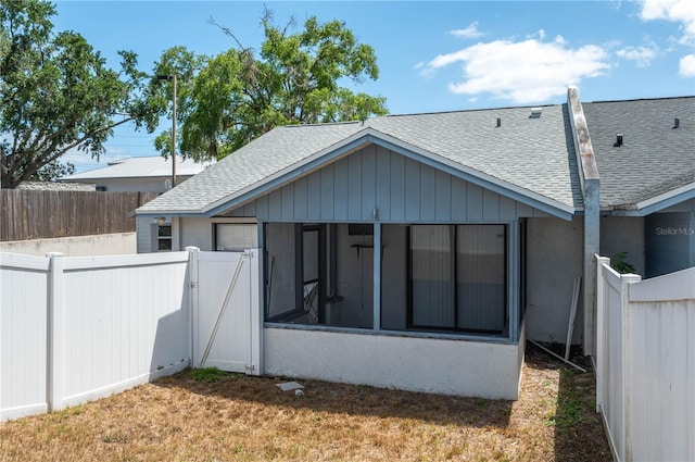 6315 Conductor Ct, Lakeland, FL 33813 - rear view of property featuring a sunroom, a shingled roof, a fenced backyard, and stucco siding