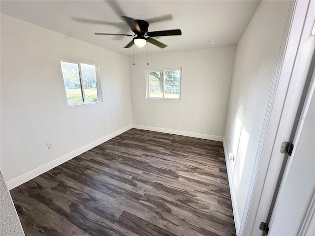 spare room featuring dark wood-style floors, baseboards, and ceiling fan