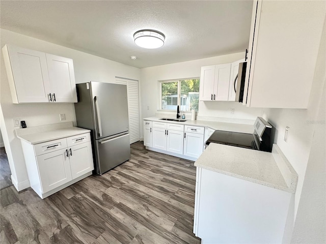2527 Dons Pl, Lakeland, FL 33801 - kitchen featuring electric stove, freestanding refrigerator, a sink, white cabinetry, and wood finished floors