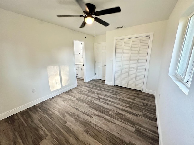 2527 Dons Pl, Lakeland, FL 33801 - unfurnished bedroom with wood finished floors, baseboards, a closet, ceiling fan, and ensuite bathroom