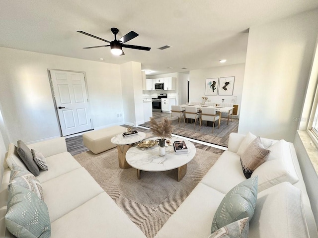 2527 Dons Pl, Lakeland, FL 33801 - living area featuring light wood-style flooring, a ceiling fan, and baseboards