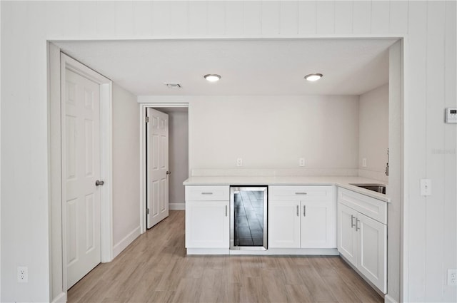 1502 Edgewater Beach Dr, Lakeland, FL 33805 - bar with light wood-type flooring, baseboards, visible vents, wine cooler, and a sink