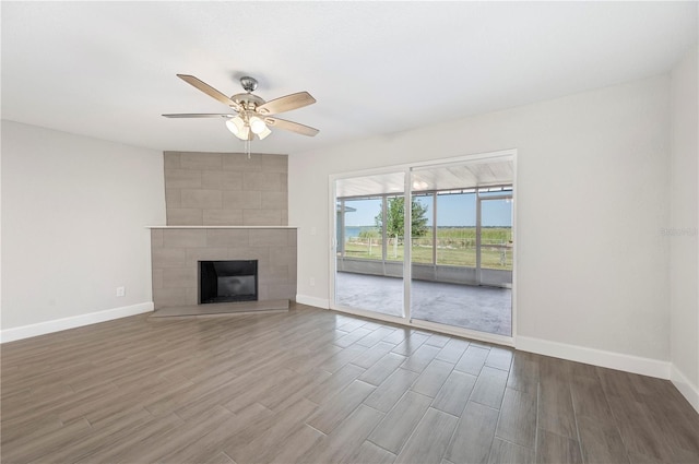 1502 Edgewater Beach Dr, Lakeland, FL 33805 - unfurnished living room with wood finished floors, ceiling fan, baseboards, and a fireplace