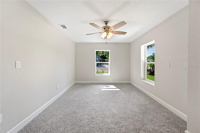 1502 Edgewater Beach Dr, Lakeland, FL 33805 - carpeted empty room featuring ceiling fan, a textured wall, visible vents, and a wealth of natural light