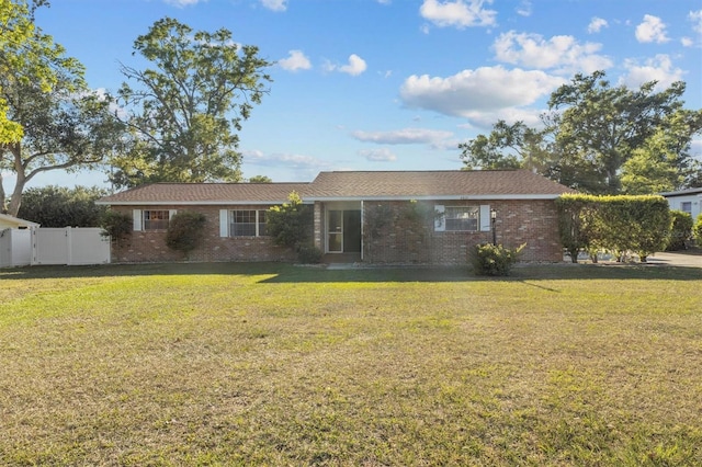ranch-style home with fence, a front yard, brick siding, and a gate
