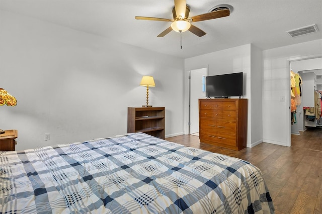 bedroom with wood finished floors, baseboards, a ceiling fan, and visible vents