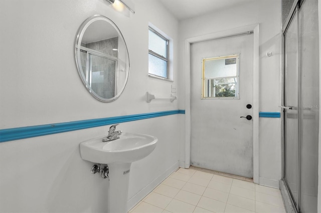 bathroom featuring a shower with door and baseboards