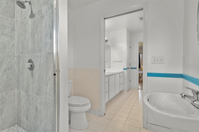 ensuite bathroom with a shower stall, tile patterned floors, vanity, and toilet