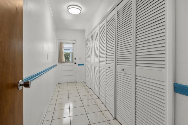 hallway with light tile patterned floors and baseboards