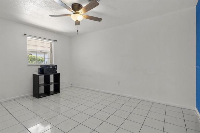 unfurnished room featuring light tile patterned floors, ceiling fan, baseboards, and a textured ceiling