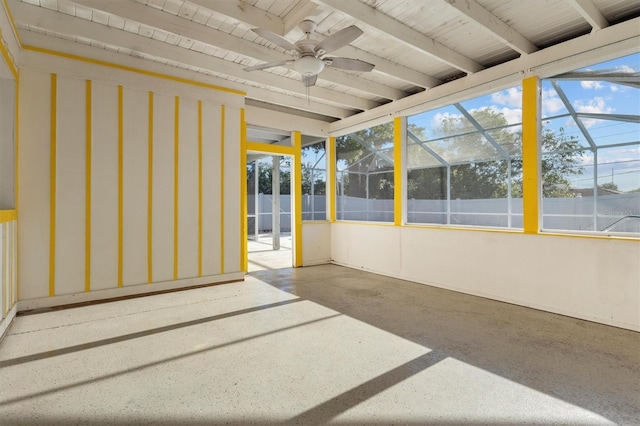 unfurnished sunroom featuring a ceiling fan, beam ceiling, and a healthy amount of sunlight