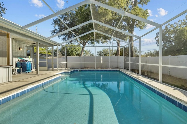view of pool with a fenced backyard, a fenced in pool, a patio area, and glass enclosure