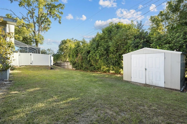 view of yard featuring an outdoor structure, fence, and a storage unit