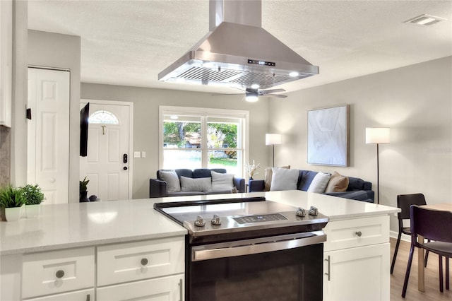 13032 Cumberland Dr, Largo, FL 33773 - kitchen with white cabinets, ventilation hood, stainless steel electric range, open floor plan, and visible vents