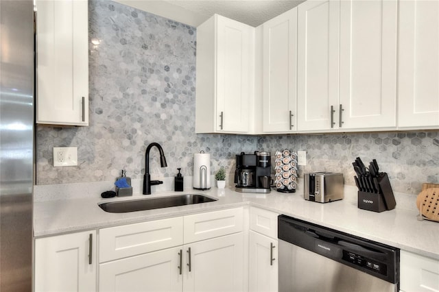 13032 Cumberland Dr, Largo, FL 33773 - kitchen featuring tasteful backsplash, a sink, light countertops, white cabinets, and appliances with stainless steel finishes