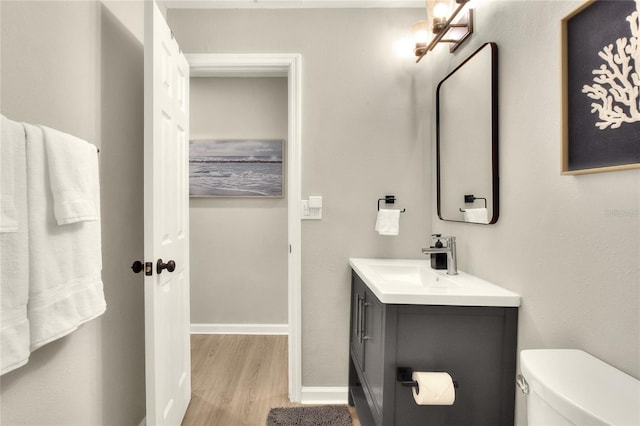 13032 Cumberland Dr, Largo, FL 33773 - half bathroom featuring toilet, vanity, wood finished floors, and baseboards
