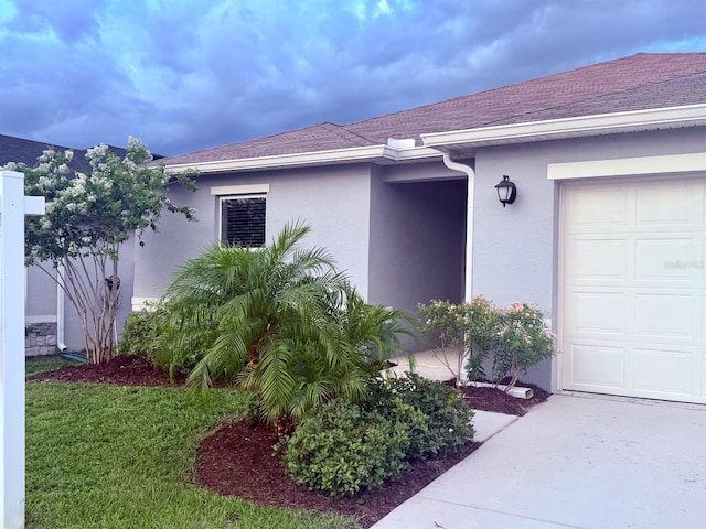 613 Sarner Pass Way, Winter Haven, FL 33881 - view of property exterior with stucco siding, roof with shingles, and an attached garage