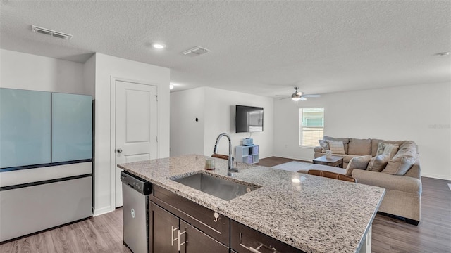 613 Sarner Pass Way, Winter Haven, FL 33881 - kitchen with dishwasher, freestanding refrigerator, a textured ceiling, dark brown cabinets, and light wood-type flooring