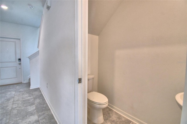 bathroom featuring toilet and baseboards