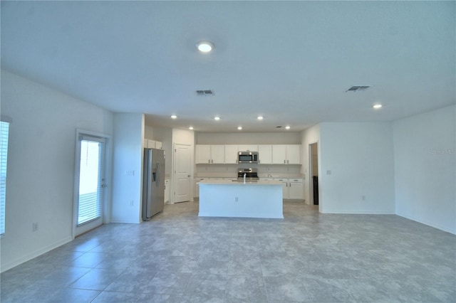 kitchen featuring white cabinets, stainless steel appliances, visible vents, a kitchen island with sink, and open floor plan