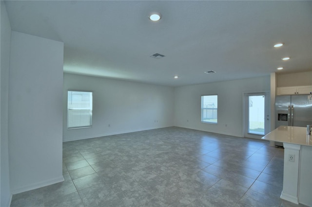 interior space with light tile patterned floors, baseboards, visible vents, and recessed lighting