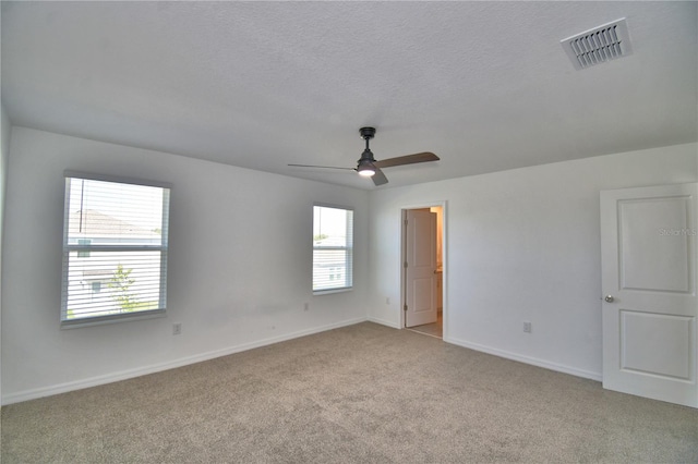 interior space featuring baseboards, visible vents, carpet, and multiple windows