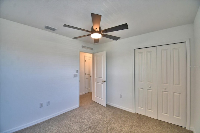 unfurnished bedroom with a closet, carpet, visible vents, and baseboards