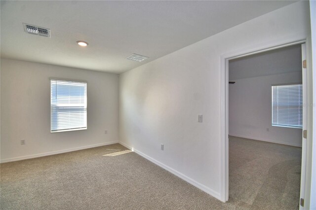 carpeted empty room with baseboards and visible vents