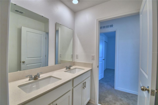 bathroom with visible vents, a sink, and double vanity