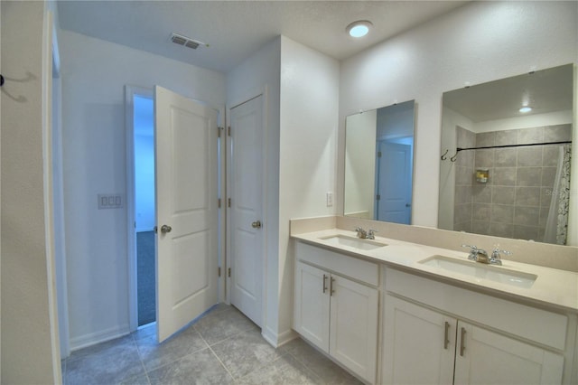 bathroom with tile patterned flooring, baseboards, visible vents, and a sink