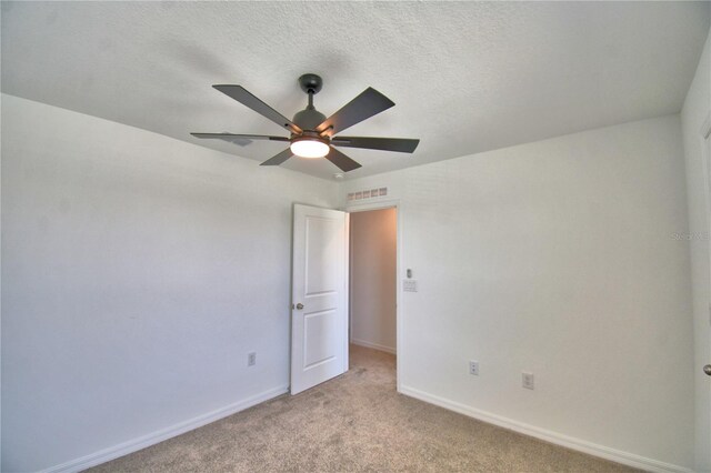 unfurnished bedroom featuring light carpet, baseboards, visible vents, and ceiling fan