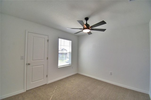 empty room with ceiling fan, baseboards, and light carpet