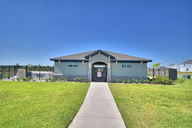 view of front of property with fence, a front lawn, and stucco siding