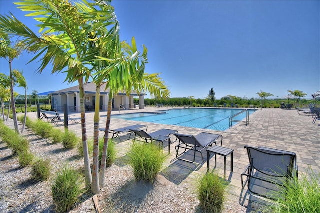 community pool with fence and a patio