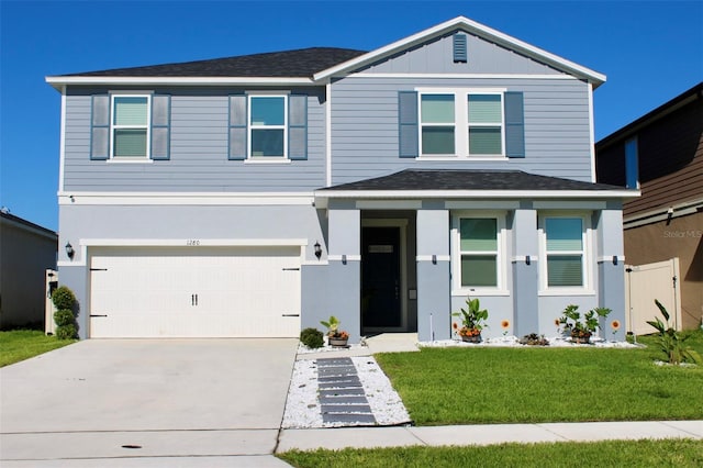 view of front of home with an attached garage, driveway, roof with shingles, and a front yard