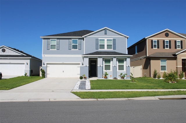 view of front of property featuring a front lawn, driveway, an attached garage, a shingled roof, and stucco siding