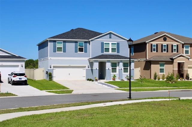 view of front of home featuring a front yard, concrete driveway, and fence