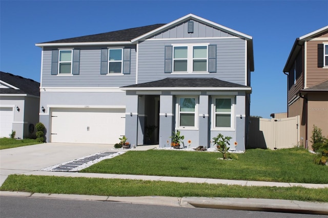 view of front facade with concrete driveway, a front lawn, board and batten siding, fence, and a garage