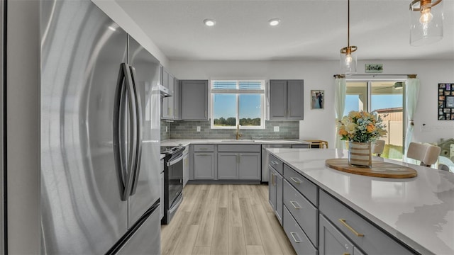 kitchen with freestanding refrigerator, backsplash, gray cabinetry, pendant lighting, and electric range oven